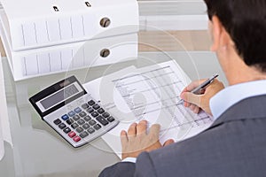 Male accountant calculating invoices