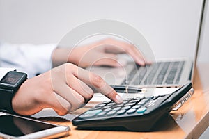 Male accountant making calculations,reviewing data in financial charts and graphs  at work place.