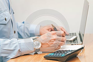 Male accountant making calculations,reviewing data in financial charts and graphs  at work place.