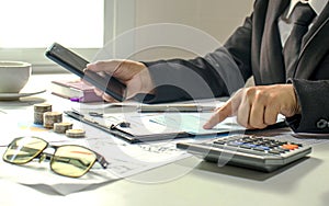 Male accountants are working on financial documents and calculators for business.