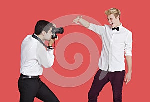 Male actor being photographed by paparazzi over red background