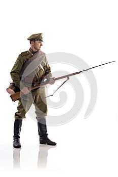 Male actor in the form of an ordinary soldier of the Russian army during the First World War posing against a white background in