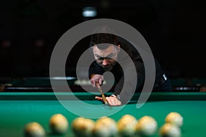 Male adult playing billiard game in club