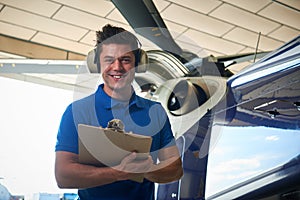 Portrait Of Male Aero Engineer With Clipboard Carrying Out Check