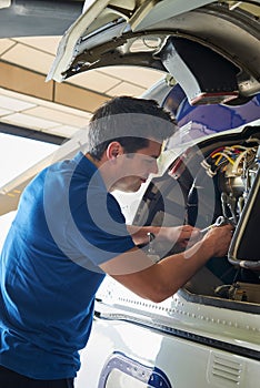 Male Aero Engineer Working On Helicopter In Hangar