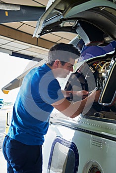 Male Aero Engineer Working On Helicopter In Hangar