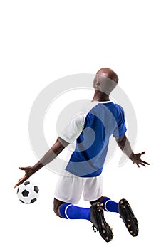 Male african american soccer player kneeling while celebrating goal on white background