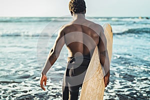 Male afro surfer having fun surfing during sunset time - African man enjoying surf day