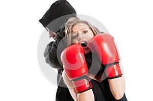 Male aggressor grabbing a frightened woman wearing boxing gloves photo