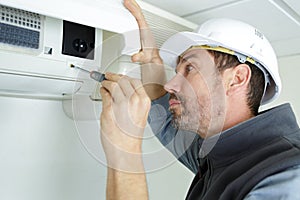 male air conditioning technician using screw driver