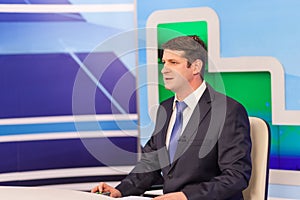 Male anchorman in tv studio. Live broadcasting