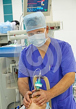 Male anesthesiologist working in operation room