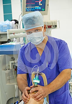 Male anesthesiologist working in operation room photo