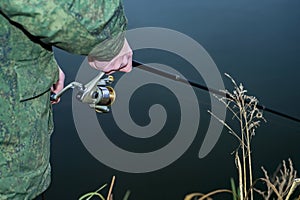 Male angler catches on a spinning fish in cold water in the offseason.