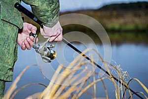 Male angler catches on a spinning fish in cold water in the offseason.