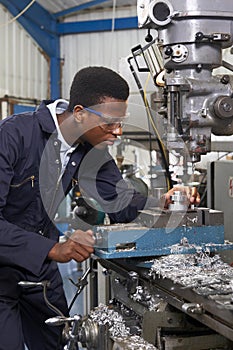 Male Apprentice Engineer Working On Drill In Factory