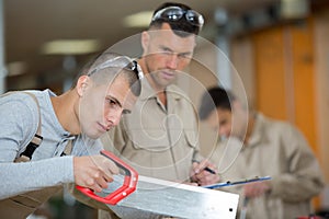 male apprentice using handsaw