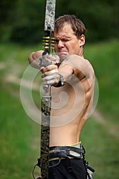 Male archer aiming at target