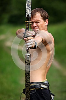 Male archer aiming at target