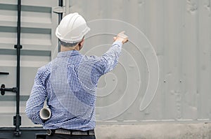 Male architect and blueprints with white helmet pointing finger on a construction site,Architects on construction site