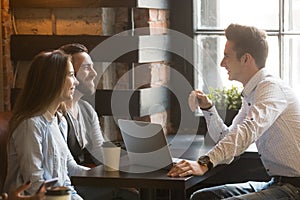 Male architect consulting excited millennial couple in coffee sh