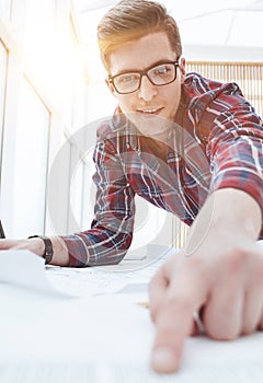 Male Architect With Digital Tablet Studying Plans In Office