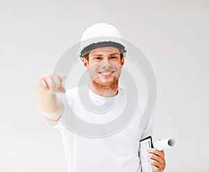 Male architect in helmet pointing at you