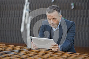 male architect holding tablet pc against building photo