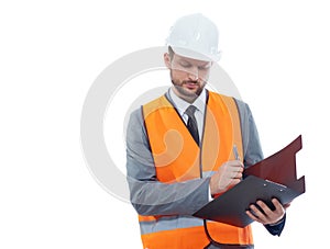 Male architect in a safety west and a hardhat writing on his cli