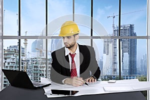 Male architect working with blueprints in the office photo