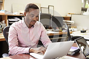 Male Architect Working At Desk On Laptop