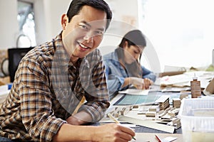 Male Architect Working On Model In Office