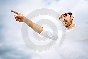 male architect working and pointing with finger on construction site