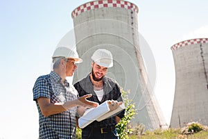 Male architects reviewing documents together at electric power