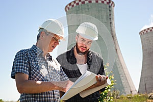 Male architects reviewing documents together at electric power