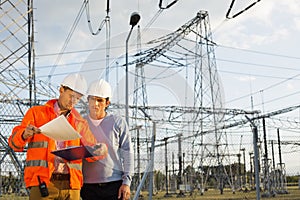 Male architects reviewing documents together at electric power plant