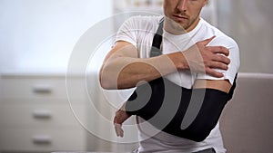 Male in arm sling suffering pain in shoulder, result of work trauma, orthopedics