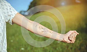 Male arm with text -I hate you- written in skin