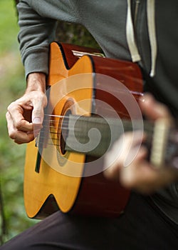 Male arms on acoustic guitar