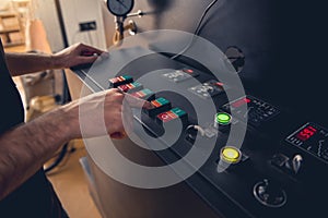 Male arms pressing button on special equipment