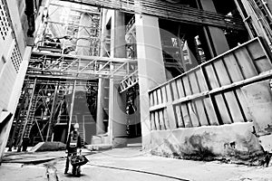 Male asian laborer wearing safety protective gear with sewage inside a wheelbarrow at cement factory. Hard work concept. Black and