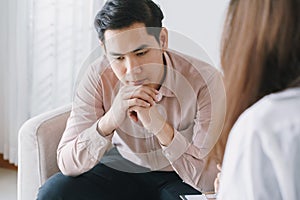 Male Asian patient with psychologist women examination consulting and psychotherapy by the physician in the clinic. psychiatrist