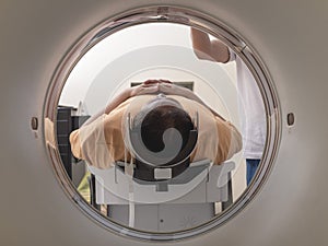 A male asian patient undergoes a CT scan at the clinic photo