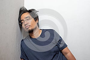 Male Asian young man feeling sick headache and coughing leaning on wall isolated on white background.Wuhan coronavirus COVID-19