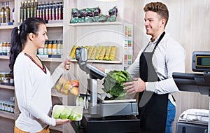 Male assistant helping customer in grocery shop