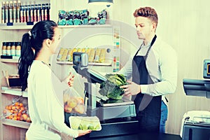 Male assistant helping customer in grocery shop