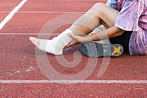 Male athlete applying compression bandage onto ankle injury