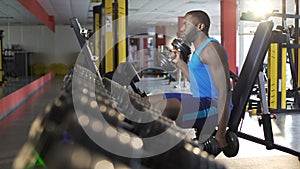 Male athlete exercising with dumbbells in gym, active healthy lifestyle, fitness