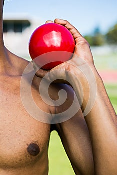 Male athlete holding shot put ball