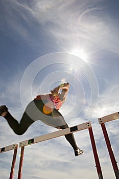 Male Athlete Jumping Hurdle